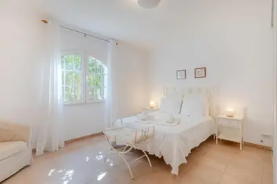 a white bedroom with a white bed and a couch at Villa Monte da Torre in Loulé