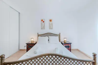 a bedroom with a large bed with white sheets at Villa Monte da Torre in Loulé