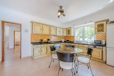a kitchen with a table and chairs in it at Villa Monte da Torre in Loulé
