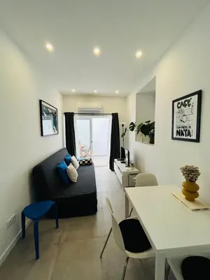 a living room with a desk and a table with chairs at Casa Eliz Modern Comfort in the center of Faro in Faro