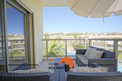 a living room with a couch and chairs and a balcony at #323 Jardins da Marina 2º BE by Home Holidays in Páteo