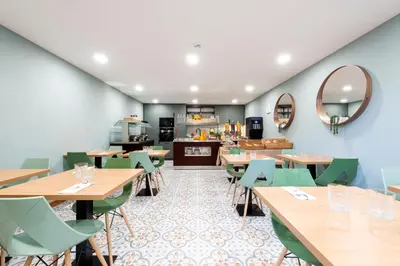 a restaurant with wooden tables and green chairs at Quinta do Moinho in Loulé