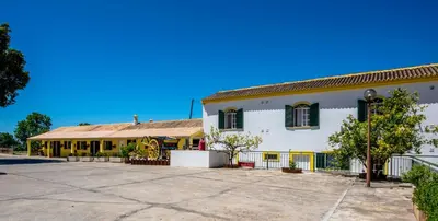 a large white building with yellow windows and a courtyard at Quinta do Moinho in Loulé