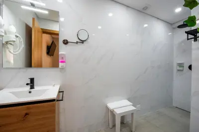 a white bathroom with a sink and a mirror at Quinta do Moinho in Loulé