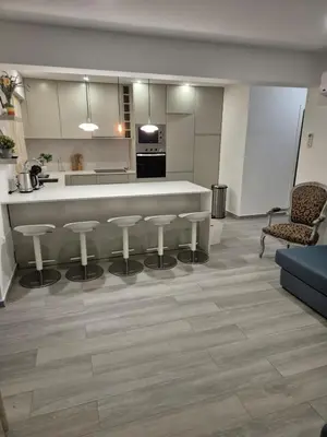 a living room with a kitchen and a counter with stools at Beautiful View Apartment in Quarteira