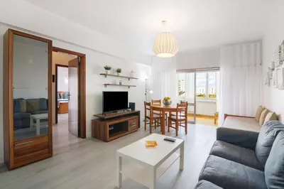 a room with a large window with white curtains at Apartamento da Praia in Quarteira