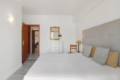 a living room and dining room with a table and a couch at Apartamento da Praia in Quarteira