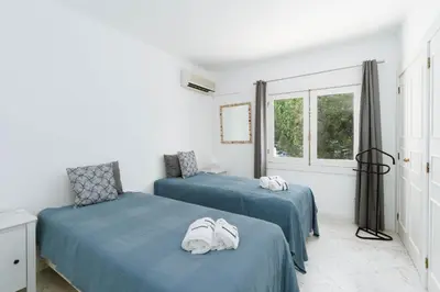 two beds in a room with blue sheets at Serenity Villa Vilamoura in Quarteira