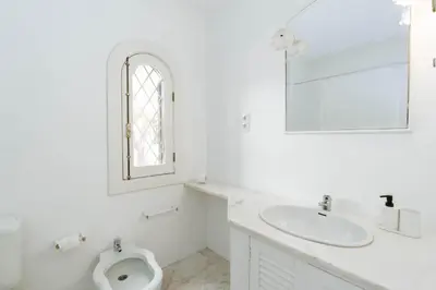 a white bathroom with a sink and a toilet at Serenity Villa Vilamoura in Quarteira