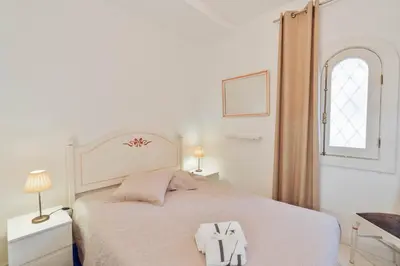 a white bedroom with a bed with two towels on it at Serenity Villa Vilamoura in Quarteira