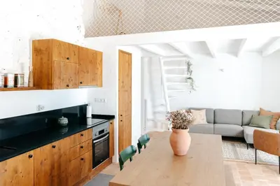 a kitchen and living room with a table and a couch at Casa Majú - Algarve in Valados