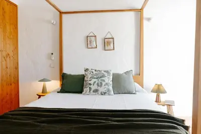 a bedroom with a large bed with a wooden headboard at Casa Majú - Algarve in Valados