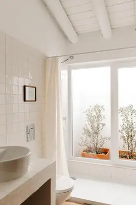 a white bathroom with a sink and a window at Casa Majú - Algarve in Valados
