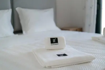a alarm clock sitting on top of a bed at Stylish Algarve Retreat- Priv. Pool & Beach Nearby in Quarteira