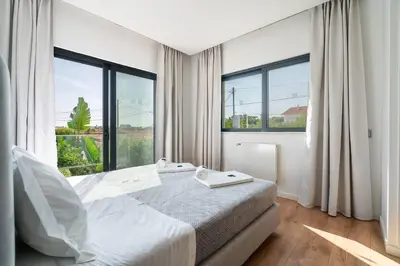 a bedroom with a bed and a large window at Stylish Algarve Retreat- Priv. Pool & Beach Nearby in Quarteira