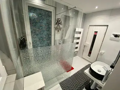 a bathroom with a glass shower and a toilet at Villa Karolina in Quarteira
