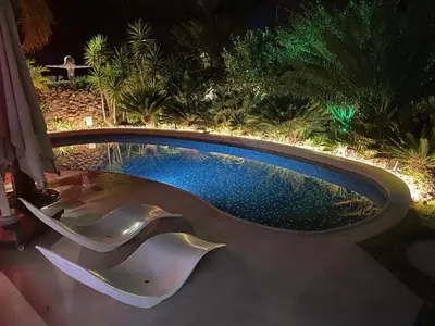 a swimming pool in a backyard at night at Villa Karolina in Quarteira