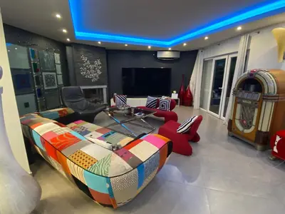 a living room with a couch and red chairs at Villa Karolina in Quarteira