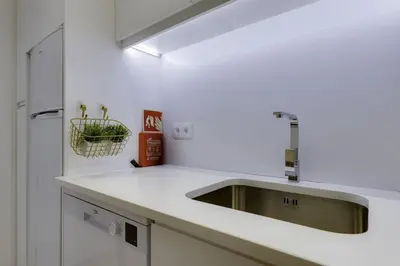 a kitchen with a sink in a white kitchen at GINGKO BILOBA ROOF TOP by My Algarve Rentals in Quarteira