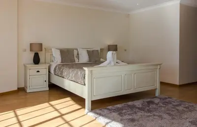 a bedroom with a white bed and two night stands at Luxury Villa with Private Pool, Gym & Leisure Room by Gale Beach LM25 in Guia