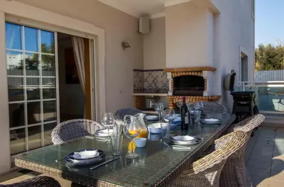 a dining room table with chairs and a fireplace at Luxury Villa with Private Pool, Gym & Leisure Room by Gale Beach LM25 in Guia