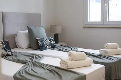 two beds with towels on them in a room at Mira Mar 1 - Near the beach by HD in Quarteira