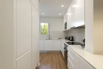 a kitchen with white cabinets and a window at Mira Mar 1 - Near the beach by HD in Quarteira