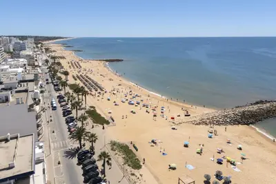 an overhead view of a beach with people and umbrellas at Mira Mar 2 - Near the beach by HD in Quarteira
