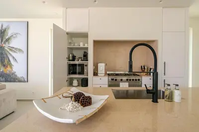 a kitchen with a table and a counter top at New Villa - Rooftop Jacuzzi & Sunset Views in Santa Bárbara de Nexe