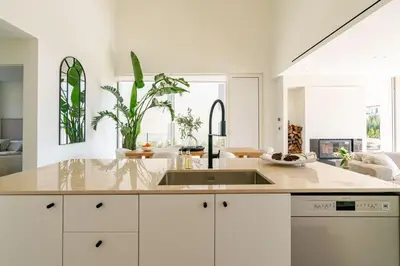 a kitchen with white cabinets and a sink at New Villa - Rooftop Jacuzzi & Sunset Views in Santa Bárbara de Nexe
