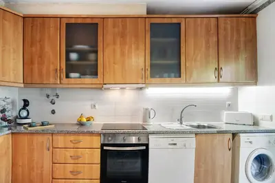 a kitchen with wooden cabinets and a dishwasher at Do Vale Hollidays in Guia