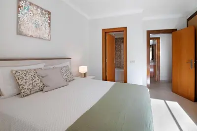 a bedroom with a large white bed with pillows at Do Vale Hollidays in Guia