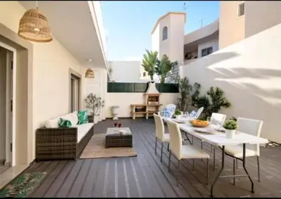 a patio with a table and chairs and a couch at Homebyvi in Quarteira