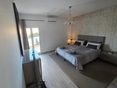 a bedroom with a bed and a sliding glass door at Casa Madalena in Albufeira