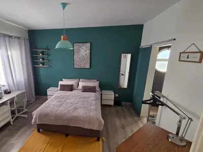 a bedroom with a bed and a blue wall at Casa Madalena in Albufeira