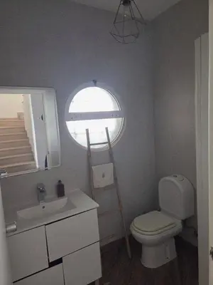 a bathroom with a toilet and a window and a ladder at Casa Madalena in Albufeira