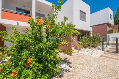 a building with a bush with flowers in front of it at Galé by the Sea in Guia