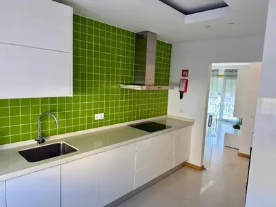 a kitchen with green tiles on the wall and a sink at Apartamento Flor de Amendoeira Garden in Albufeira