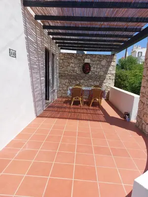 a patio with two chairs and a table on it at Jacaranda 43-Moradia terrea in Albufeira