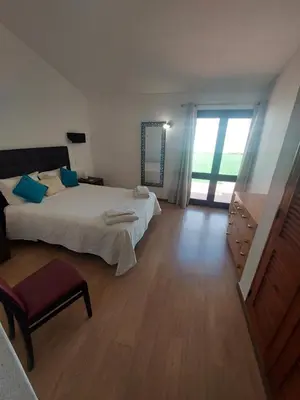a bedroom with a large bed and a large window at Jacaranda 43-Moradia terrea in Albufeira