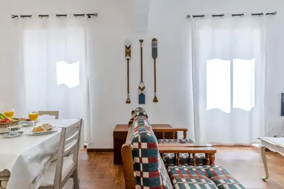 a dining room with white curtains and a table and chairs at #341 Casa da Guida 44 by Home Holidays in Olhos de Água