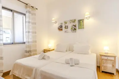 two beds in a bedroom with white walls and a window at #341 Casa da Guida 44 by Home Holidays in Olhos de Água