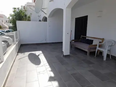 a patio with a couch and a table and chairs at Oura House in Albufeira