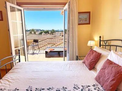 a bedroom with a bed and a view of a patio at Casa Antonius, Sun & Pool Balaia Home by BeCherish in Atalaia