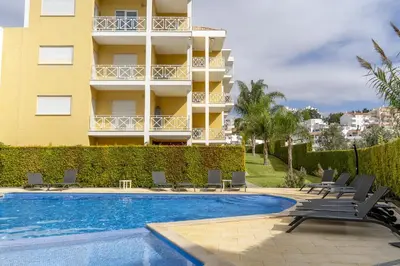 a hotel with a swimming pool and chairs and a building at #340 Old Town Garden Hill Z by Home Holidays in Albufeira