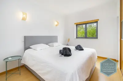 a bedroom with a white bed with a backpack on it at Quinta do Pinheiro Residence AF - Dream Lodging in Albufeira