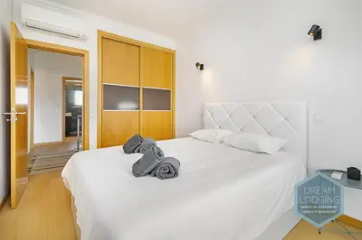 a bedroom with a white bed with towels on it at Quinta do Pinheiro Residence AF - Dream Lodging in Albufeira