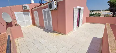 a balcony of a house with pink walls and doors at Vila Paraiso da Maria 5 quartos duas salas, jardim, piscina, varanda com churrasqueira e WIFI in Olhos de Água