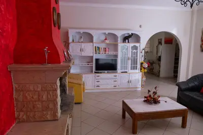 a living room with a fireplace and a tv at Vila Paraiso da Maria 5 quartos duas salas, jardim, piscina, varanda com churrasqueira e WIFI in Olhos de Água