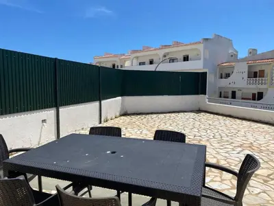 a black table and chairs on a patio with a fence at Maryland Terrace by RPG Properties in Albufeira